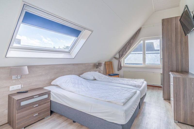 Spacious bedroom in Holiday home Kamperfoelie 49, De Koog, Texel, with skylight and comfortable beds.