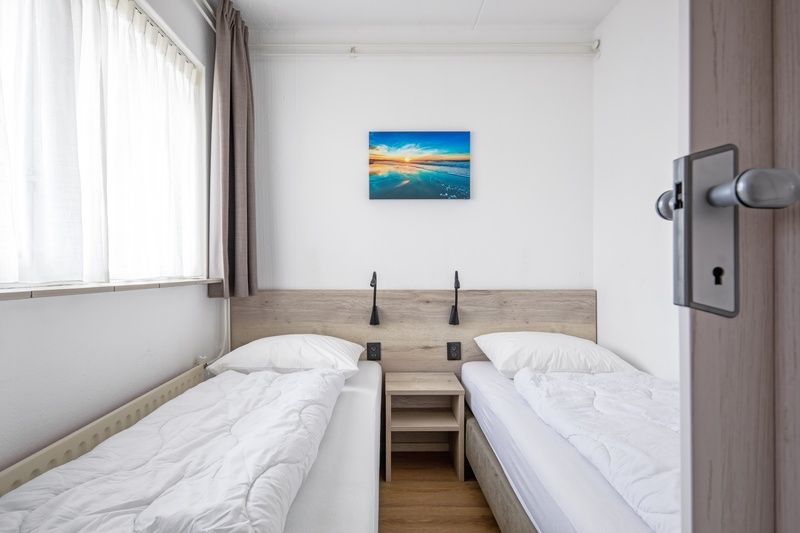 Rustikales Schlafzimmer mit zwei Betten in Zwei Personen Wohnung klein - Erdgeschoss, De Koog, Texel, bietet Komfort und Ruhe.