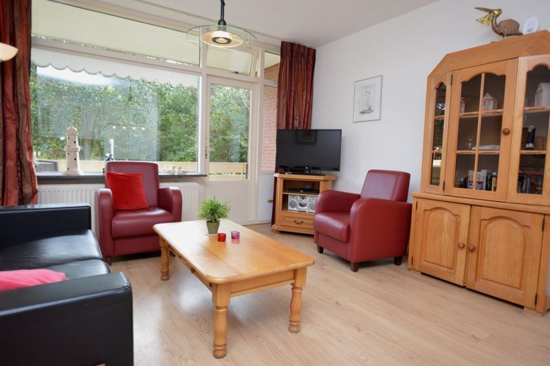 Geraeumiges Wohnzimmer der Ferienwohnung Kerckeland 110 in De Koog Texel mit Blick auf die Natur.