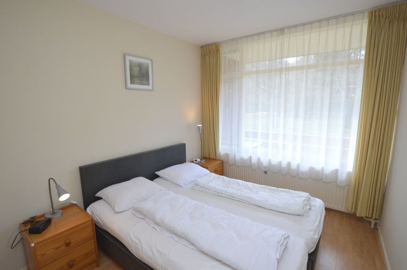 Comfortable bedroom in Apartment Kerckeland 24, De Koog, Texel with large window and serene ambience.