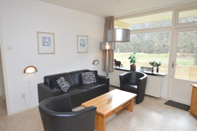 Stilvolle Sitzecke im Appartement Kerckeland 28, De Koog, Texel mit Blick auf die gruene Umgebung.