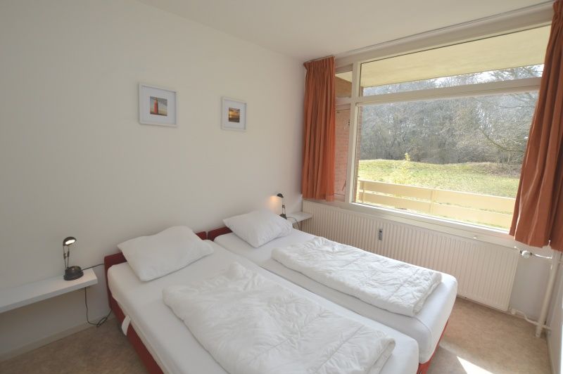 Komfortables Schlafzimmer im Apartment Kerckeland 28, De Koog, Texel mit Doppelbett und Blick auf die Natur.