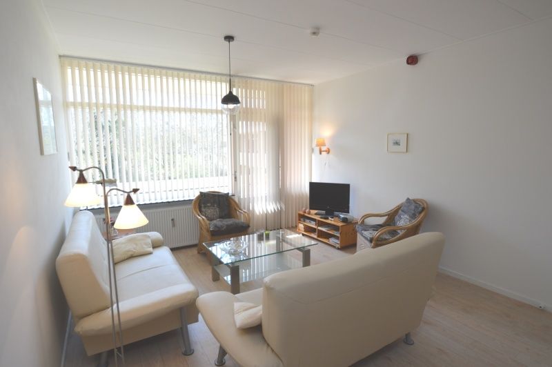 Bright living room with large windows in Apartment Kerckeland 80, De Koog, Texel, ideal for relaxation.