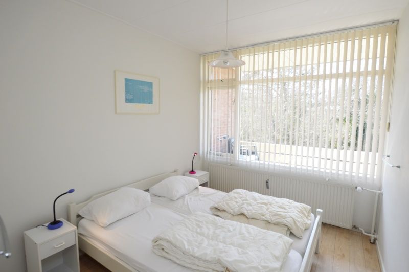Bright bedroom with double bed in Apartment Kerckeland 80, De Koog, Texel, overlooking nature.