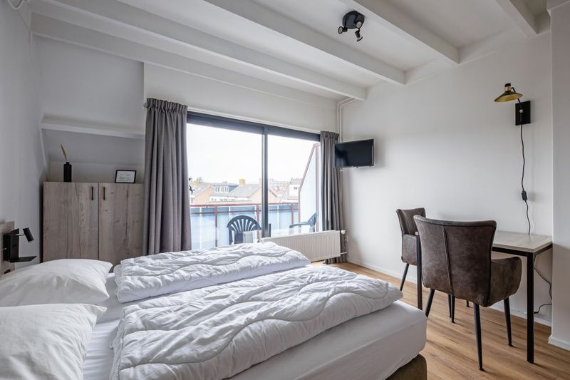 Spacious bedroom with balcony in Two person studio - second floor, De Koog, Texel for a relaxing stay.