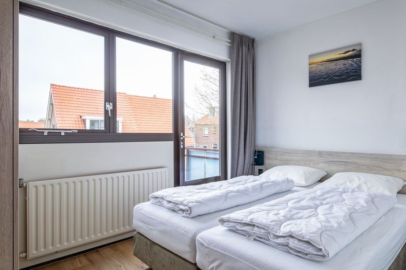 Komfortables Zimmer in Zwei Personen Wohnung gross - erster Stock, De Koog, Texel mit Blick auf die Daecher der Watteninseln.