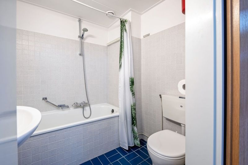 Modernes Badezimmer in Zwei Personen Wohnung gross - erster Stock, De Koog, Texel mit Badewanne und Dusche zur Entspannung.