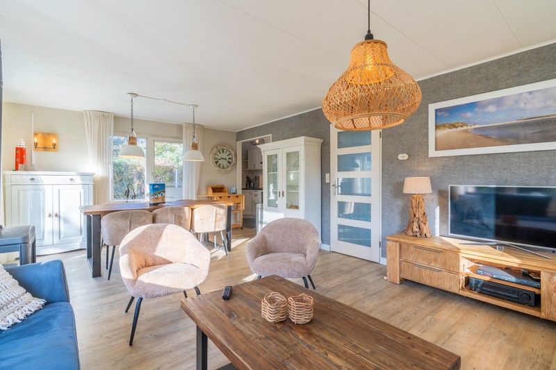 Dining room and living room in Holiday home Honeysuckle 57, De Koog, Texel offer a warm atmosphere on the Wadden Islands.