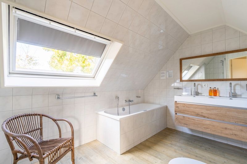 Spacious bathroom with bathtub in Holiday home Honeysuckle 57, De Koog, Texel for ultimate relaxation on the Wadden Islands.