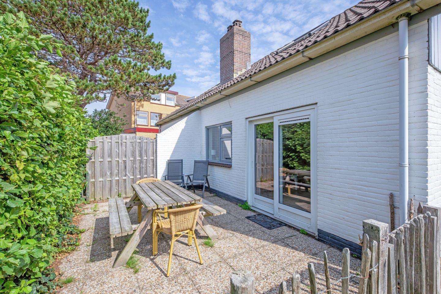 Sunny terrace with wooden seating at 32a Castor vacation home, De Koog, Texel.