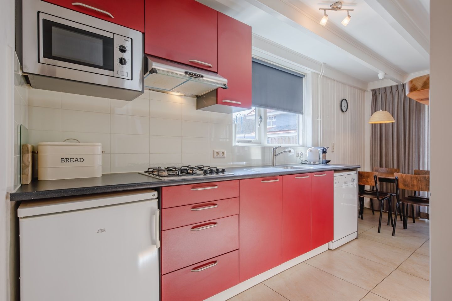 Modern kitchen in 32a Castor vacation home, De Koog, Texel, with red cabinets.