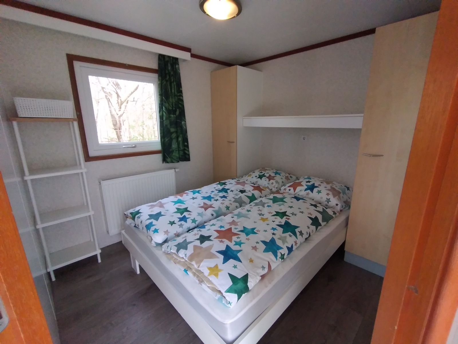 Attractive bedroom in Chalet Uit en Thuis, De Koog, Texel, with double bed and colorful blankets.