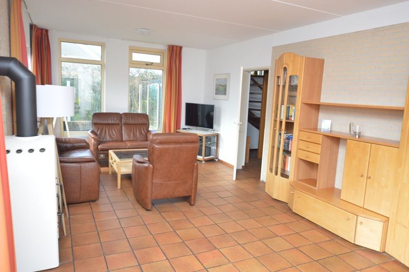 Cozy living room in Holiday home Stappeland 199, De Koog, Texel, with comfortable leather sofas and lots of natural light.