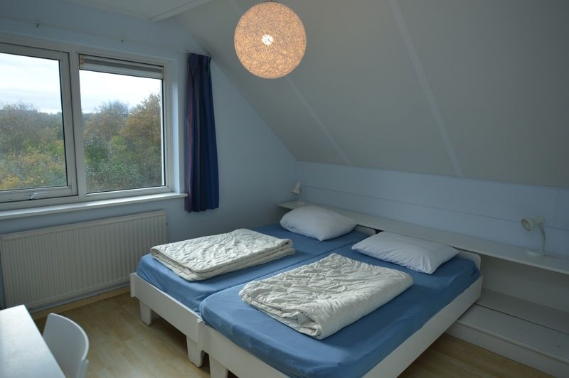 Spacious double room in Holiday home Stappeland 199, De Koog, Texel, with comfortable bed and view of nature.