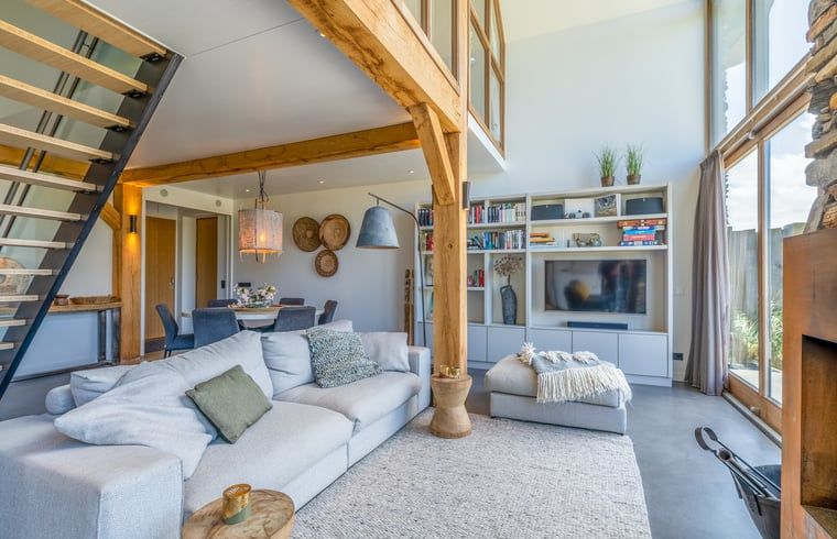 Open living room in Holiday Home in De Koog with comfortable sitting area and bookshelves.