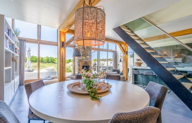 Dining table in cottage in De Koog overlooking terrace and nature of Texel.
