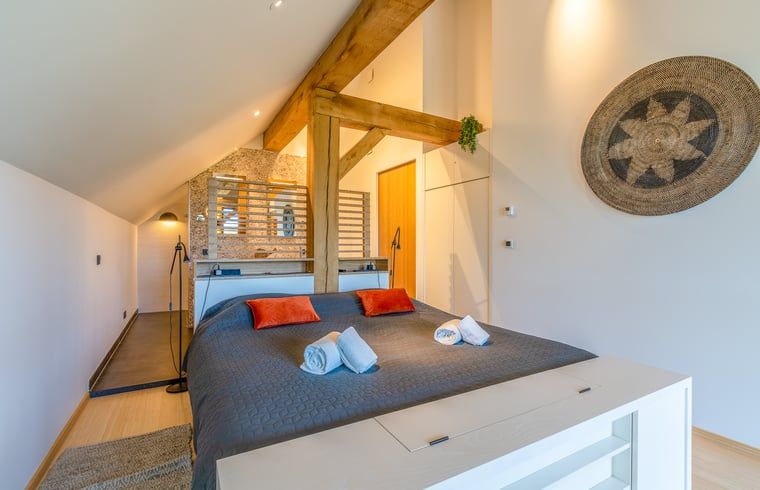 Bright upstairs bedroom in Holiday home in De Koog, Texel, with wooden beams.