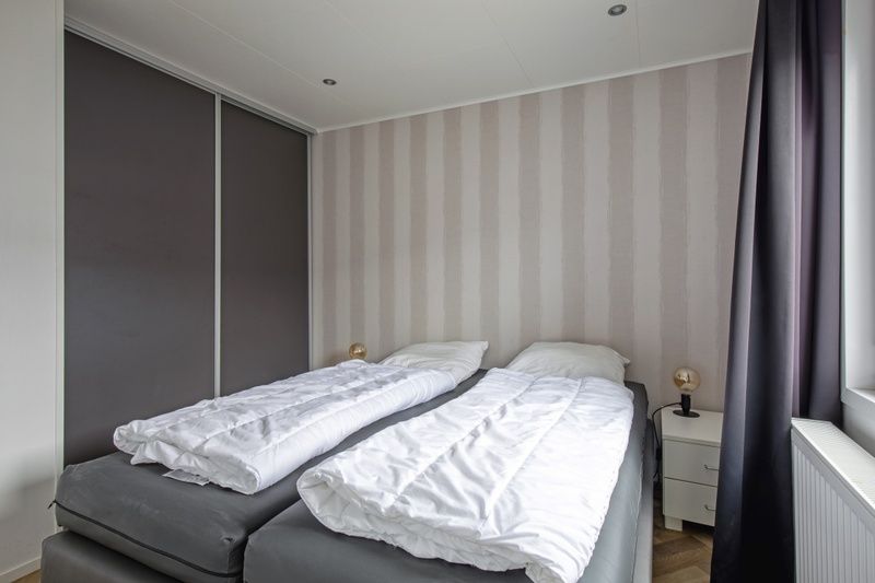 Second bedroom in Chalet Bregkoog 162, De Koog, Texel with two single beds and practical storage space.