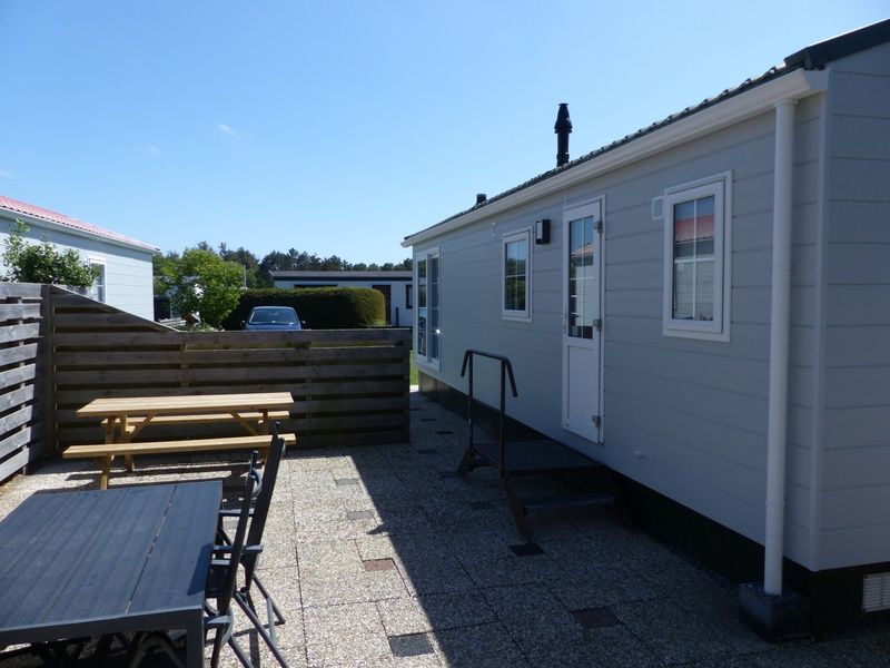 Terrace of Chalet Bregkoog 205, vacation home in De Koog Texel with outdoor furniture.