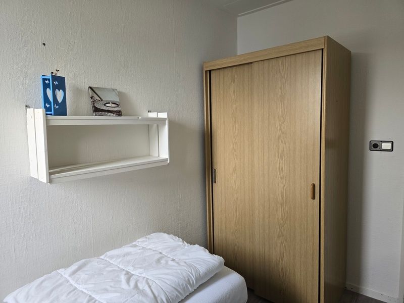 Stauraum im Schlafzimmer von Apartments Anna - Apartment 15 in De Koog, Texel, mit Holzschrank und Wandregal.