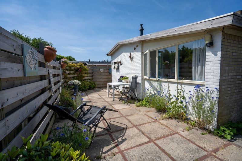 Sonnige Terrasse mit Liegestuehlen im Ferienhaus 2490, De Koog, Texel, ideal zum Entspannen.