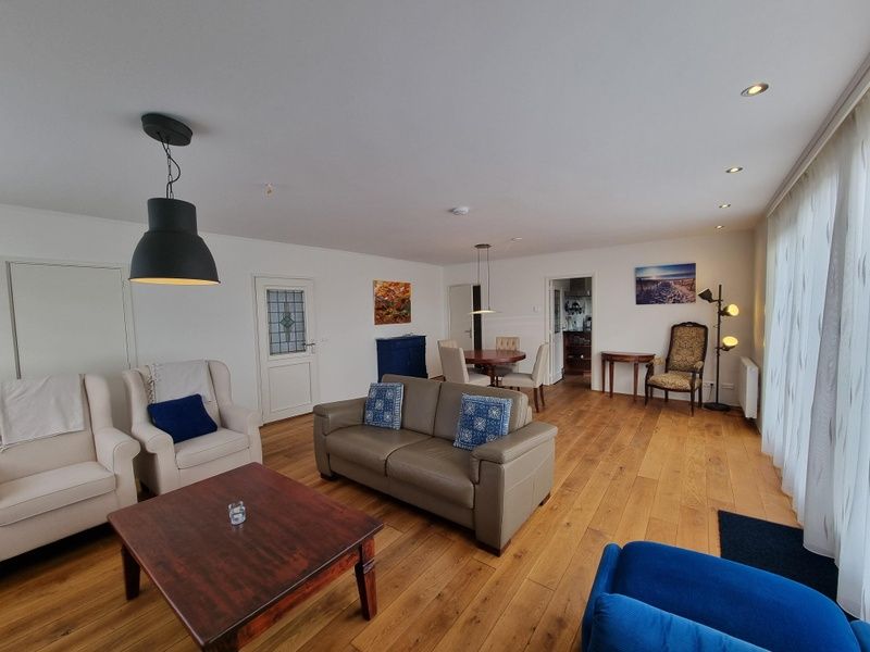 Open living space in Bungalow Epelaan 13, De Koog, Texel, with modern furniture and wooden floor.