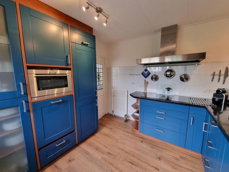 Modern kitchen in Bungalow Epelaan 13, De Koog, Texel, with built-in appliances and ample storage space.