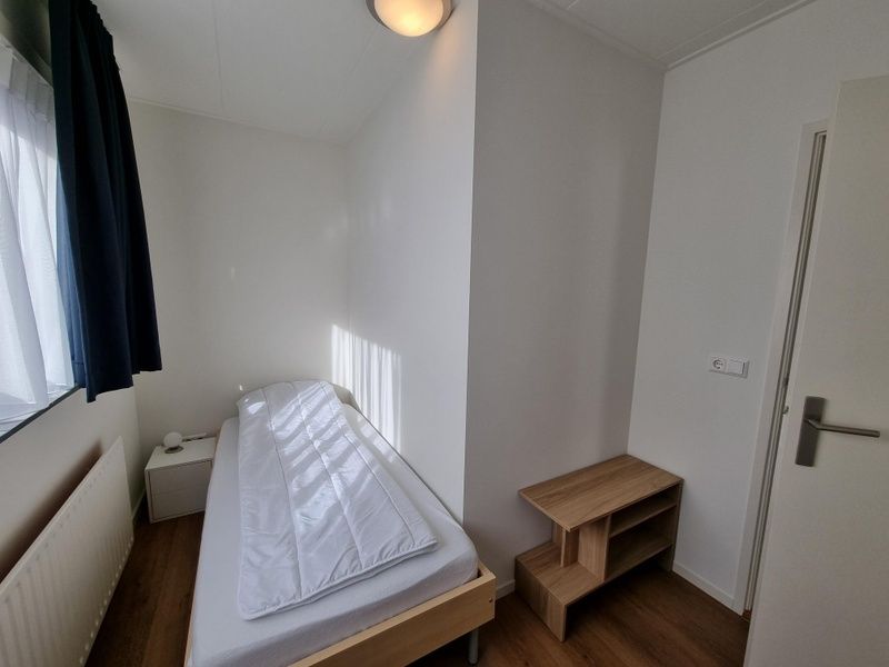 Cozy single room in Bungalow Epelaan 13, De Koog, Texel, with minimalist furnishings.