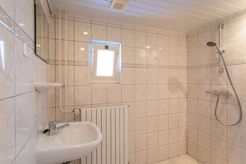 Stilvolles Badezimmer im Bungalow 1, De Koog, Texel mit Dusche und modernen Fliesen fuer mehr Komfort.
