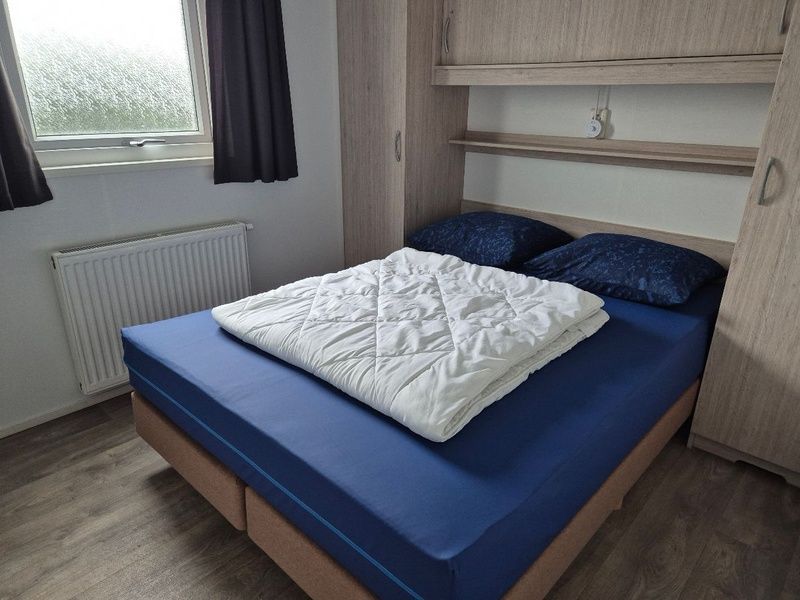 Master bedroom of Chalet Bregkoog 47 'De Muy' in De Koog, Texel. Comfortable bed for a good night's sleep.