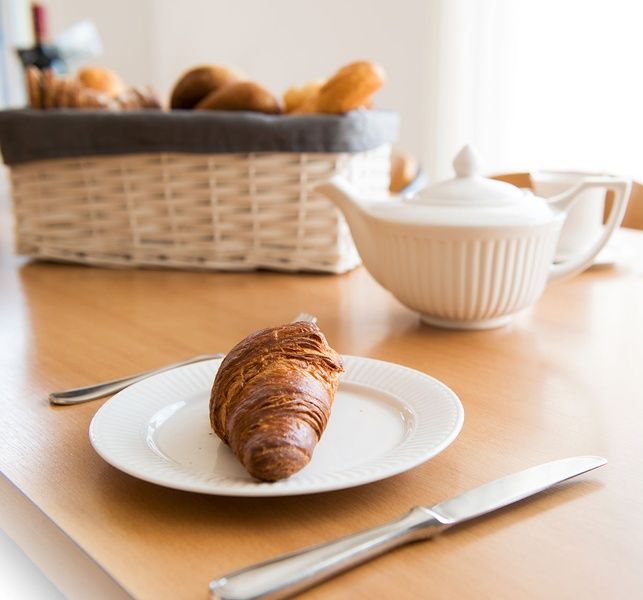 Breakfast with croissant in Villa 6, De Koog Texel, cozy vacation home on the Wadden Islands.
