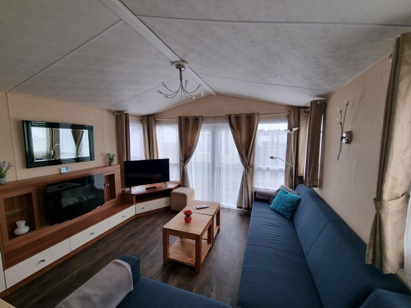 Cozy living room in Chalet Bregkoog 16 Zanderij, De Koog Texel, with comfortable seating area and large windows.