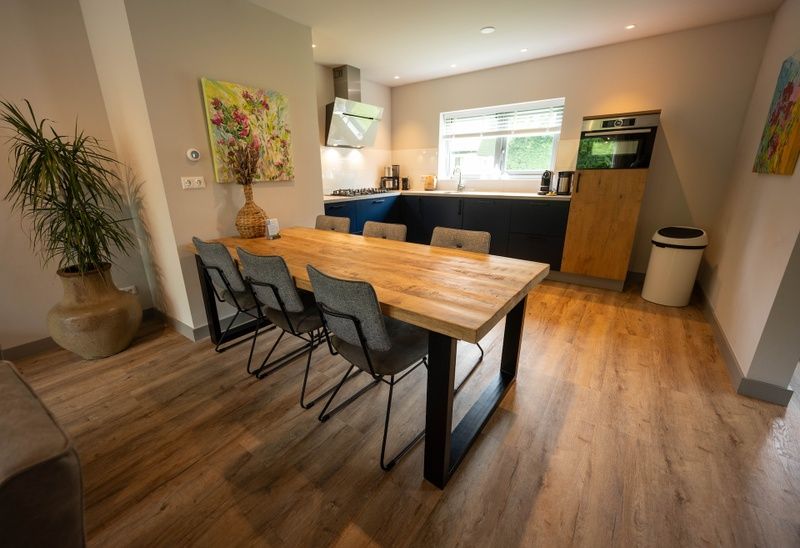 Dining area in Landgoed Springtij - Stulpje in De Koog Texel with wooden table and comfortable chairs.