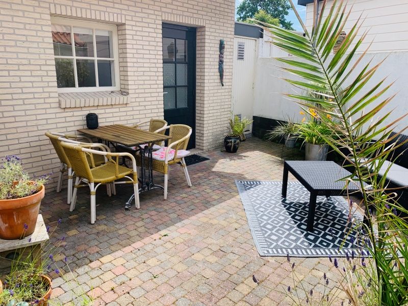 Aussenbereich des Ferienhauses Texel D, De Koog, Texel, mit farbenfrohem Wandgemaelde und bequemen Sitzgelegenheiten.