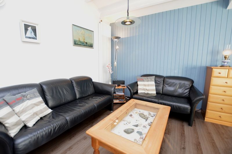 Comfortable seating area in Motel Texel - Apartment 315/1T, De Koog, Texel with leather sofas and a rustic coffee table.