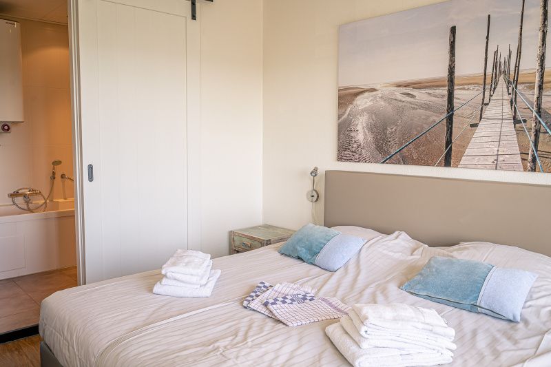Gemuetliches Schlafzimmer mit Kunst an der Wand im Appartement Juliana 172 Eilandzicht, De Koog Texel, perfekt fuer einen entspannten Aufenthalt.