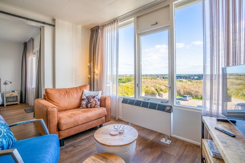 Geraeumiges Wohnzimmer mit bequemen Sitzgelegenheiten im Appartement Juliana 172 Eilandzicht, De Koog Texel, ideal fuer einen Urlaub.