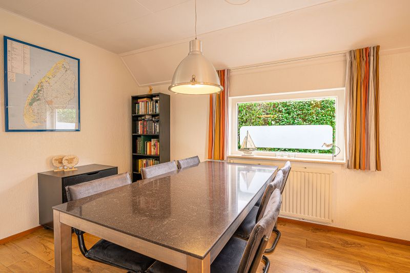 Dining room in Holiday home Honeysuckle 43 with sauna, De Koog, Texel, offers a cozy place for meals overlooking the garden.
