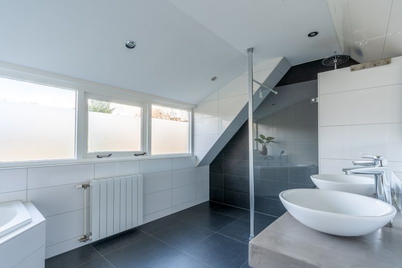 Spacious bathroom of Holiday home Kamperfoelie 43 with sauna in De Koog, Texel, with modern walk-in shower and double sink.