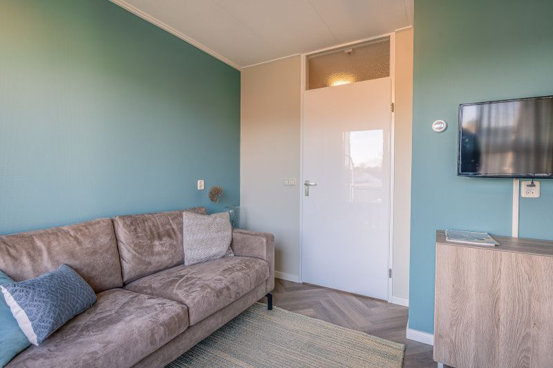 Modern furnished living room with TV in Apartment Zeedistel 24, De Koog, Texel.