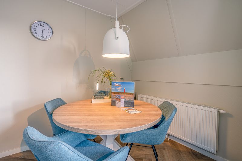 Stylish dining area with round table in Apartment Zeedistel 24, De Koog, Texel.