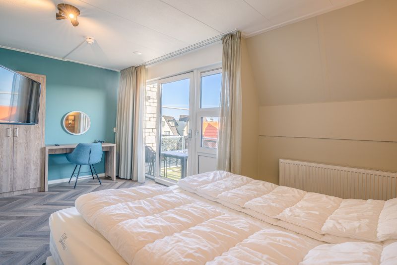 Spacious bedroom with balcony in Apartment Zeedistel 24, De Koog, Texel.