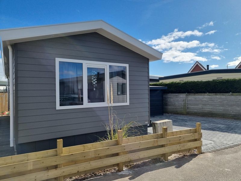 Chaletpark Bregkoog - Chalet 45 TX45 in De Koog, Texel, charmante Fassade mit Holzzaun und sonniger Lage.