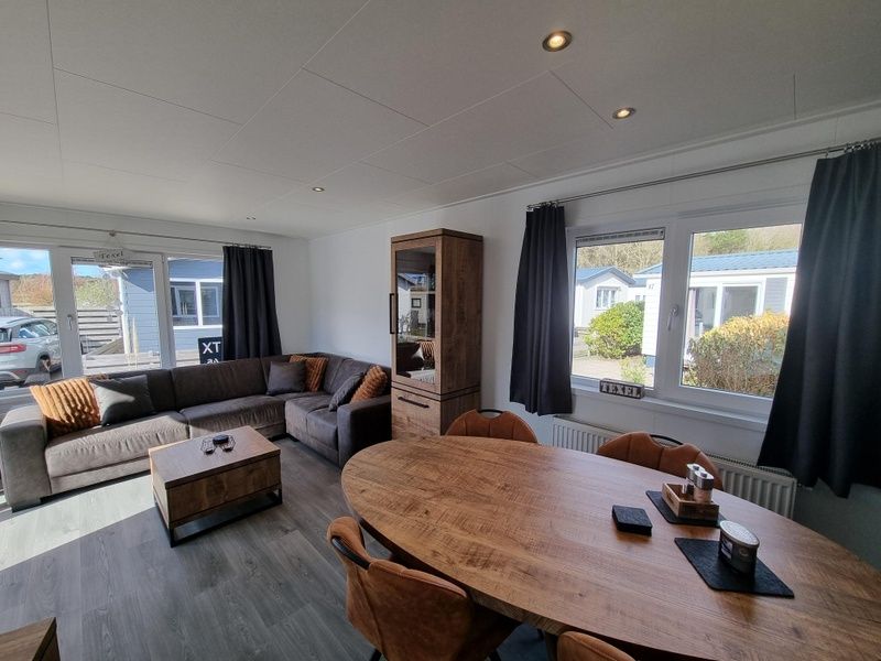 Chaletpark Bregkoog - Chalet 45 TX45 in De Koog, Texel, gemuetliches Wohnzimmer mit Ecksofa und Essecke.