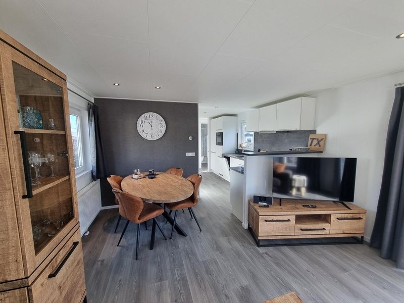 Chaletpark Bregkoog - Chalet 45 TX45 in De Koog, Texel, modernes Esszimmer mit Holztisch und bequemen Stuehlen.