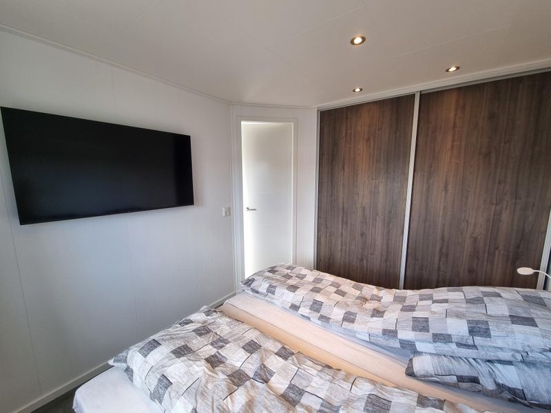 Chaletpark Bregkoog - Chalet 45 TX45 in De Koog, Texel, Schlafzimmer mit TV und Einbauschraenken fuer zusaetzlichen Komfort.