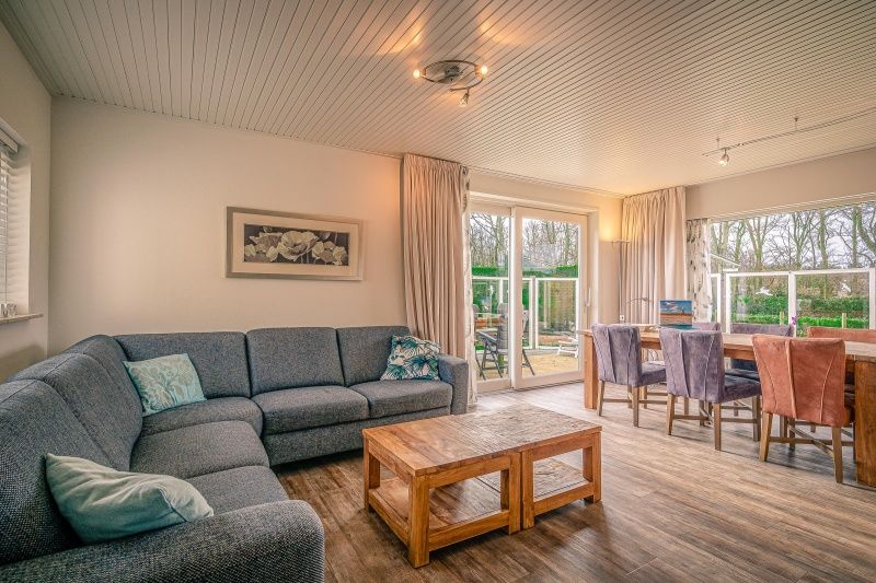 Spacious living room of Orchismient 2, vacation home in De Koog, Texel with comfortable sofa and dining area.