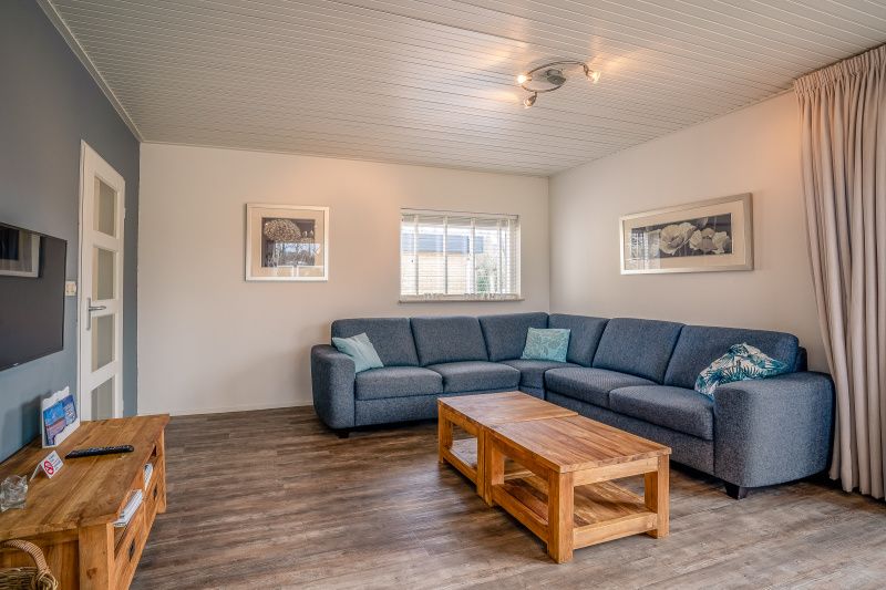 Cozy sitting area in Orchismient 2, vacation home Texel, with large sofa and wooden coffee table.
