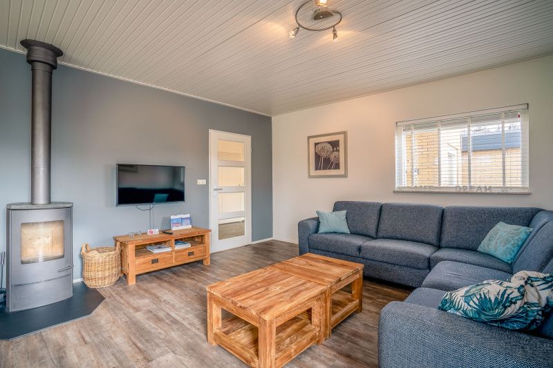 Modern living room with wood stove in Orchismient 2, vacation home De Koog, Texel.