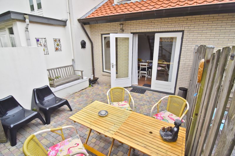 Sunny terrace at vacation home Texel A, De Koog, with cozy seating.